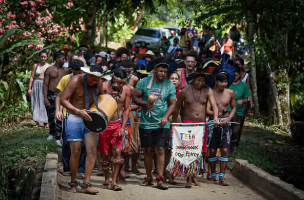 A group of Afro-Brazilian and Indigenous people on a march in the rainforest