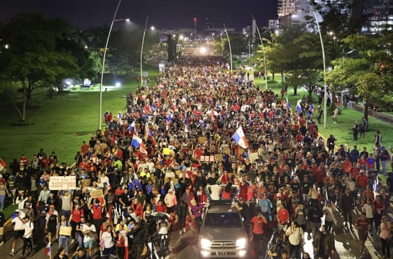A protest march with thousands of people fills a street in the capital