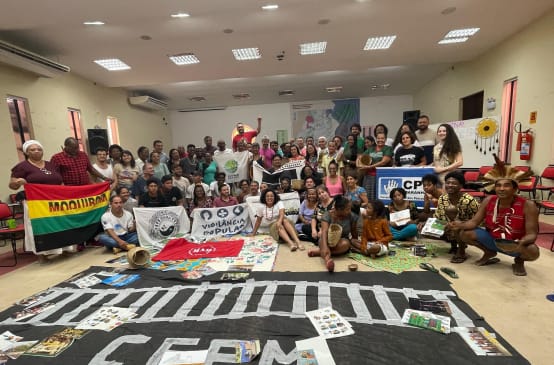 Group photo of around 50 people with banners in a seminar room