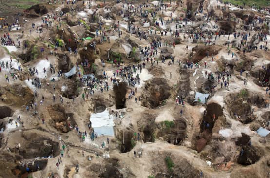 Deep holes, some filled with water, with many people in between. View from above