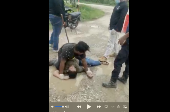 A villager is assaulted by plantation workers
