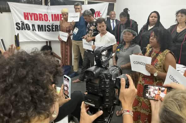 A group of ten people who conducted the symbolic trial are filmed with a camera and cell phones