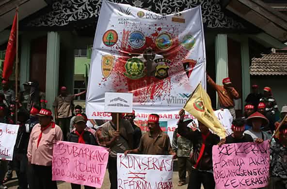 Protesters walk with banners against oil companies