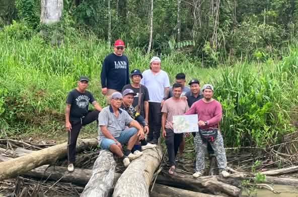 Indigenous Sungai Seruas people display a map they and SADIA produced