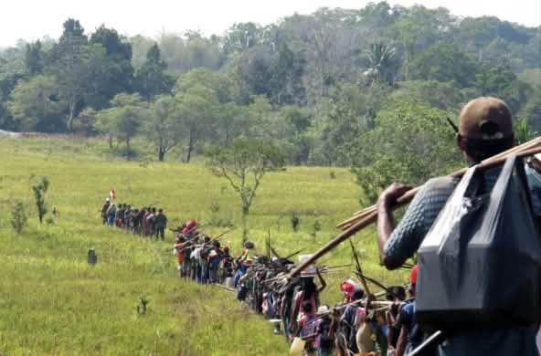 Indigenous hunters cross a savanna