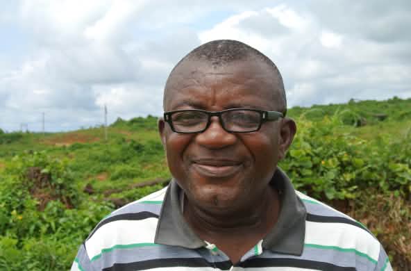 Odey Oyama stands on land that has been clear-cut for a plantation