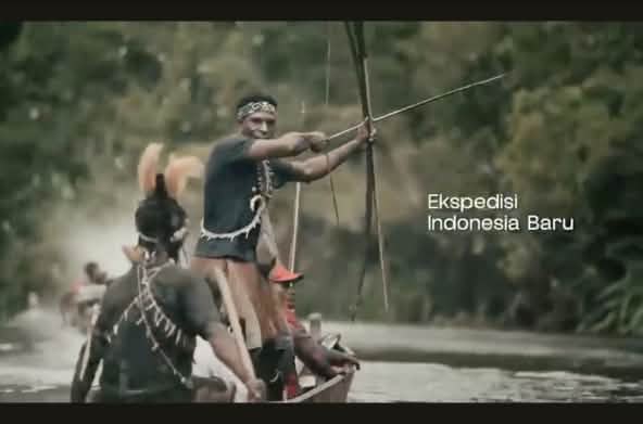 Papuans in a small boat armed with a bow and arrows