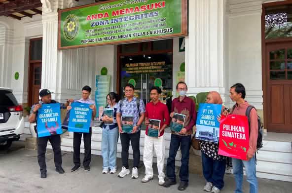 Eight activists in front of a courthouse