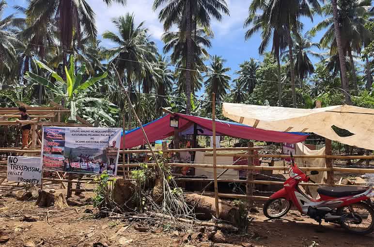 Awnings erected by the community to prevent the mining company from entering the coconut plantation, with signs reading ‘No trespassing – private property’