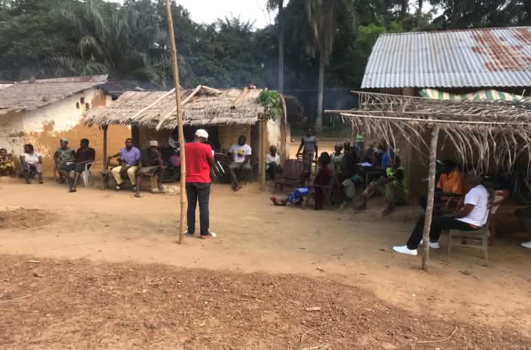 CAD activist (red shirt) speaking to villagers