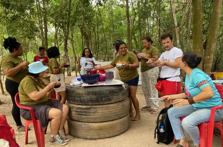 A group of nine people having lunch and chatting around an improvised table