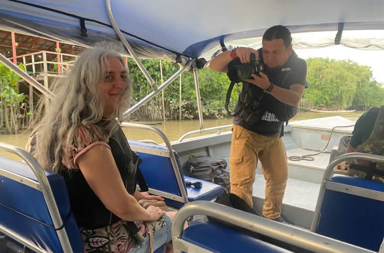 A journalist takes a photo of Rainforest Rescue environmentalist Guadalupe Rodríguez on a boat.
