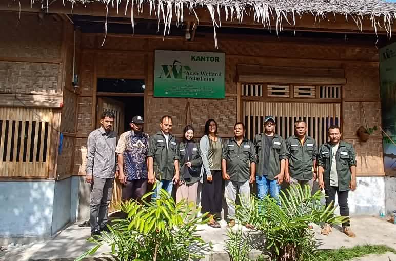 Group photo of the AWF team in front of the office building made of rattan and bamboo
