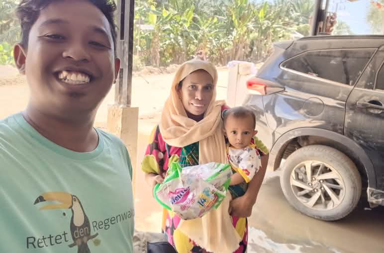 Syukur in a Rainforest Rescue t-shirt and a woman with a baby