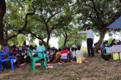 A TASHA field officer talks about the dangers of oil projects in a village