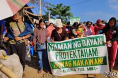 A group of people holding a banner that reads (translated): “Protect the wealth of the people! Stop the theft! Alliance Against Mining”