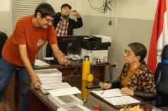 A human rights activist hands the petition to the President of the Indigenous Institute, who is sitting at her desk