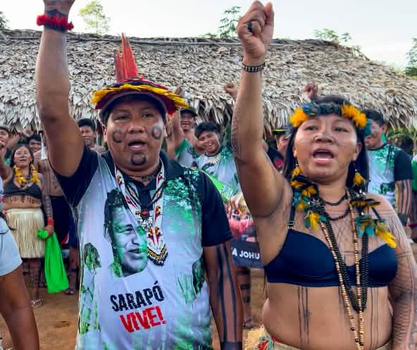 Three indigenous Ka'apor—two women and one man—with raised fists
