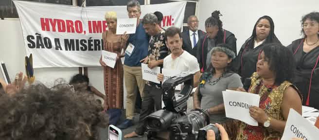 A group of ten people who conducted the symbolic trial are filmed with a camera and cell phones