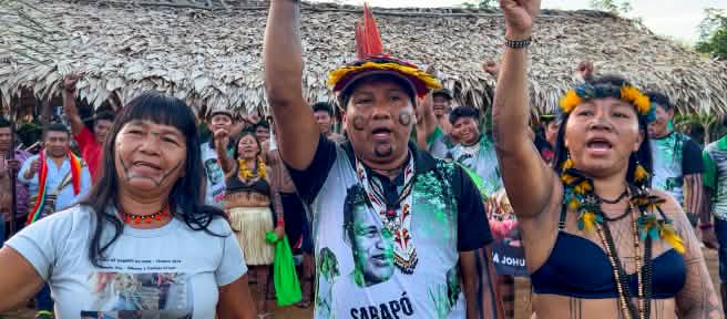 Three indigenous Ka'apor—two women and one man—with raised fists