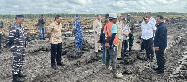 Officials and military personnel on clear-cut land