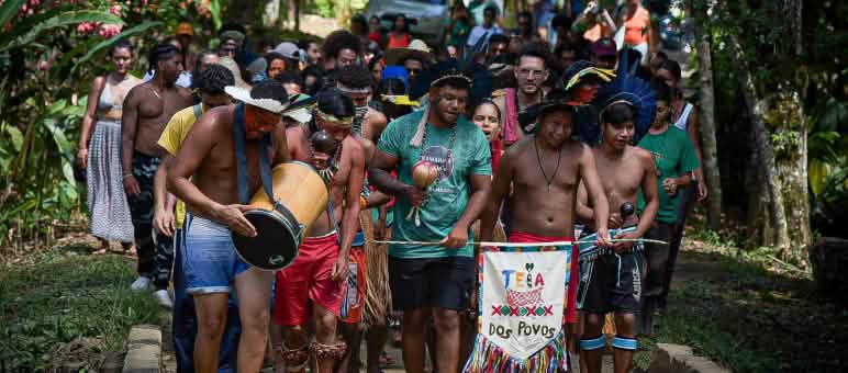 A group of Afro-Brazilian and Indigenous people on a march in the rainforest