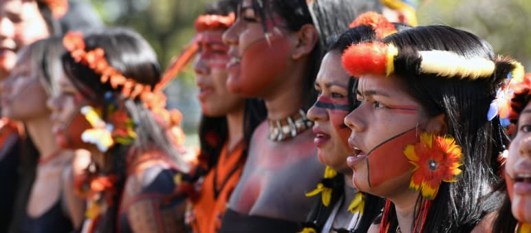 Young Indigenous women adorned with feathers