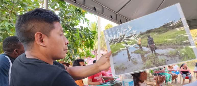 An Awa Guajá man looks at a photo he is holding up