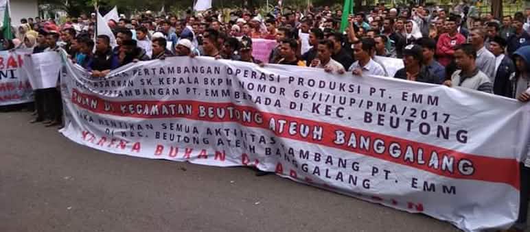 Protest march with a "stop mining!" banner