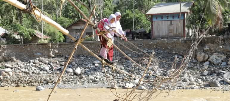 Two schoolgirls on an improvised rope bridge