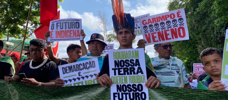 Indigenous peoples’ march for the rainforest during the Amazon summit in Belém Indigenous people marching in a row holding up placards with slogans such as: “Our land is our future”