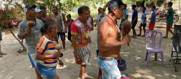A group of Indigenous Akroá-Gamella dance in a circle with calabash rattles in their hands