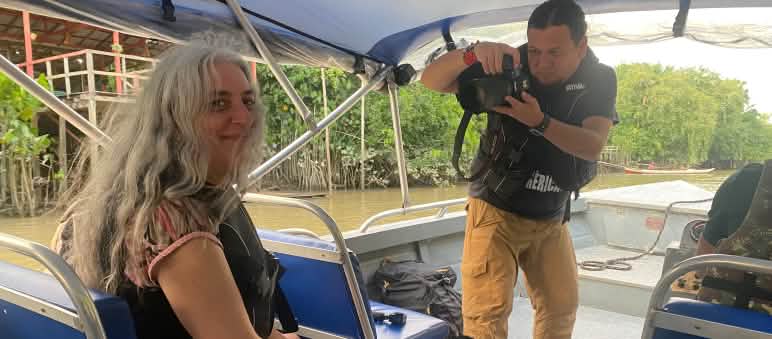A journalist takes a photo of Rainforest Rescue environmentalist Guadalupe Rodríguez on a boat.