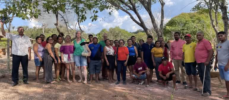 30 people lined up for a group photo under trees