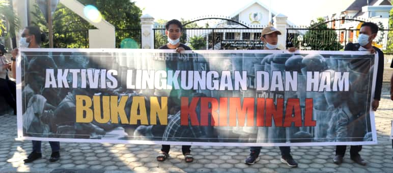 Solidarity banner: "Environmental and human rights activists are NOT CRIMINALS" JATAM solidarity banner