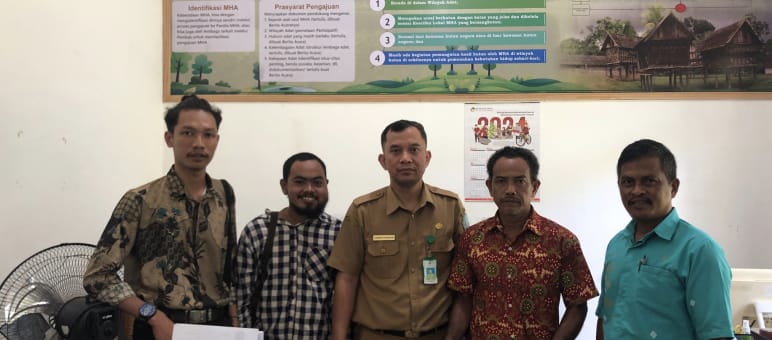 Five men pose in the office of a government agency