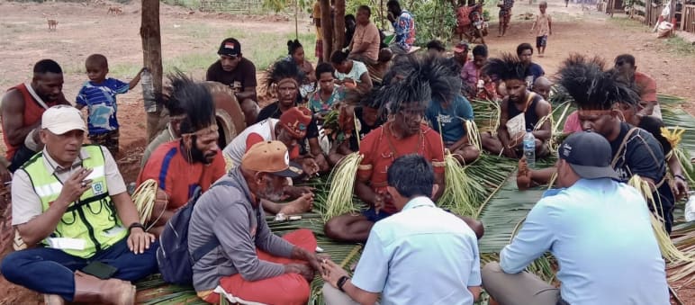 Environmental destruction and deforestation are severely punished under the traditional law of the Indigenous Marind people of Papua, Indonesia. A ritual confirms the verdict. A group of Papuans sitting on palm leaves