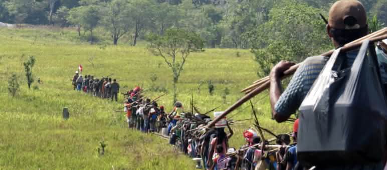 Indigenous hunters cross a savanna