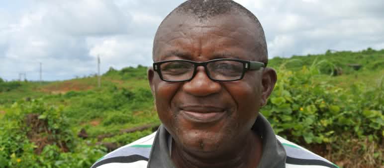 Odey Oyama stands on land that has been clear-cut for a plantation