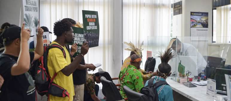 Right: Indigenous Papuans bearing signs: "Papua needs justice, not exploitation"