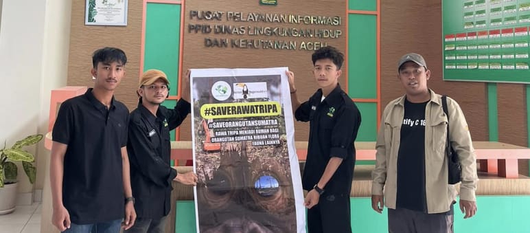 Four people with a large #SaveRawaTripa banner
