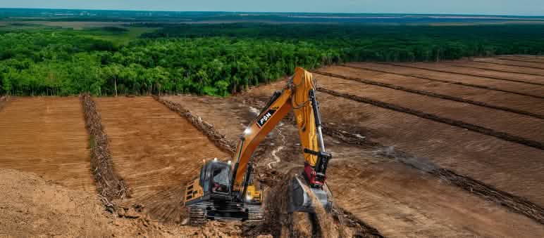 Clear-cutting rainforest for sugar and ethanol (PSN Merauke) Excavator on deforested land – the forest in the background is threatened