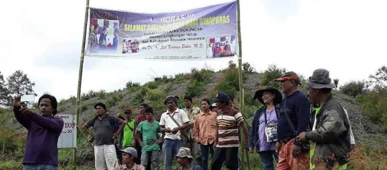A group of protesters with a banner on a hill