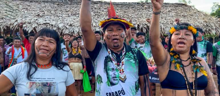 Ka'apor people protesting against the planned carbon trading project in their rainforest Three indigenous Ka'apor—two women and one man—with raised fists
