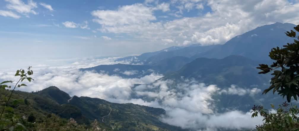 Mountain landscape with white clouds hugging the ground and above in the sky