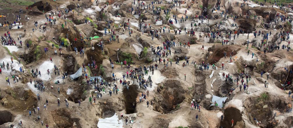 Deep holes, some filled with water, with many people in between. View from above