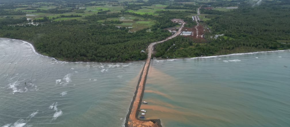 A brown jetty leads from the nickel mine in the rainforest out to sea. Aerial view