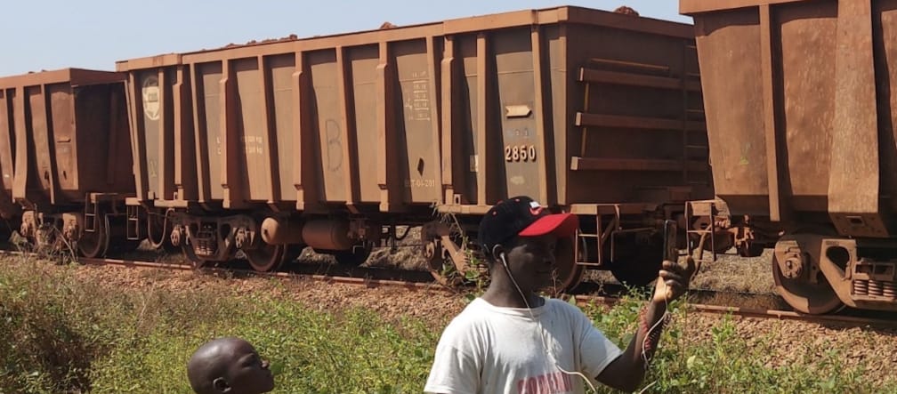 A freight train, a boy and a man in the foreground