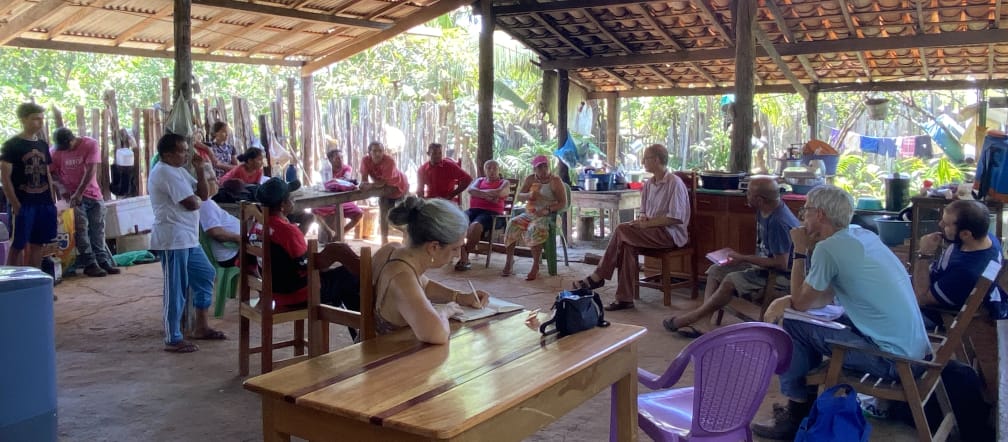 A group of people at a meeting in an open hut