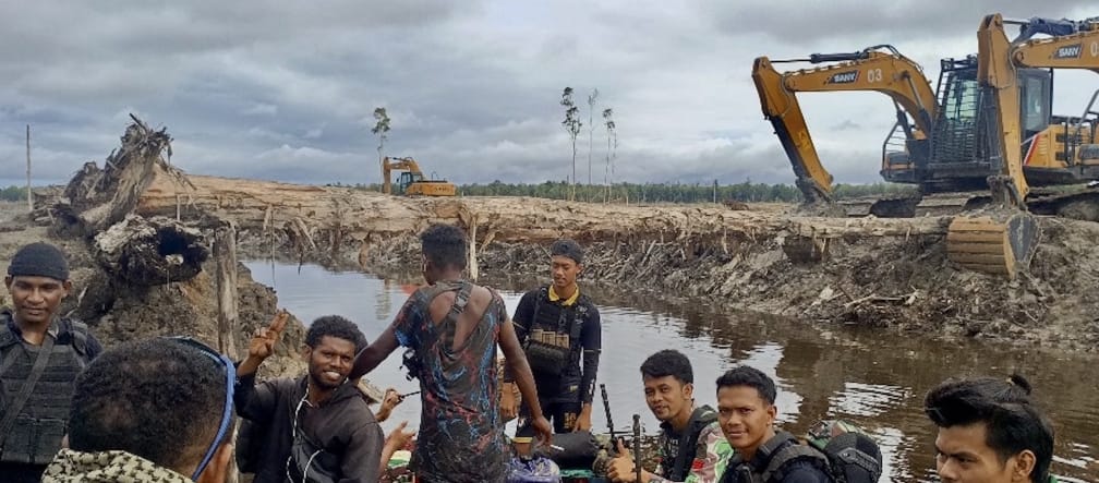 Excavators behind a group of men